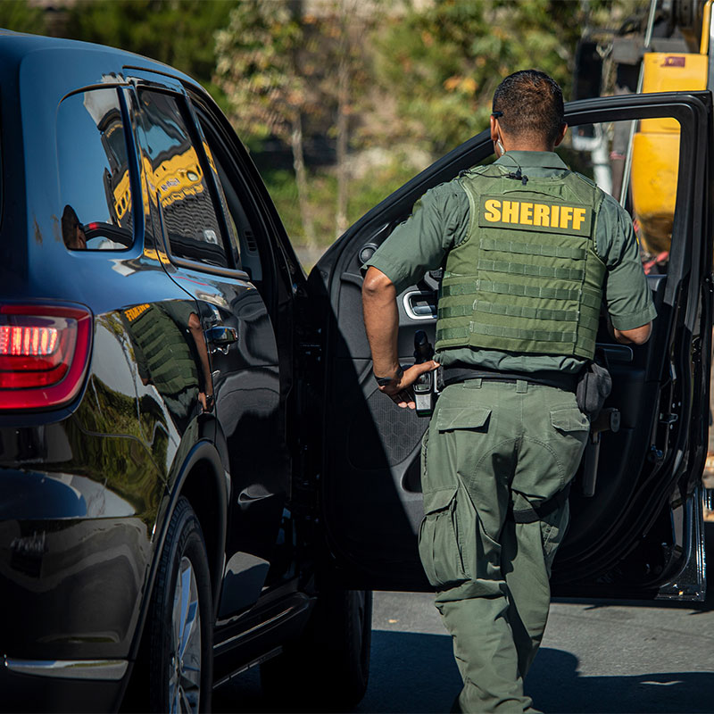 sheriff deputy standing by his vehicle